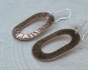 Oval copper earrings with texturing from a hammer.