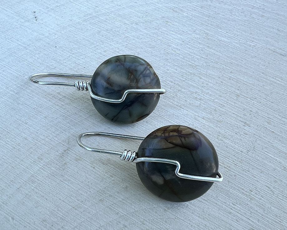 Round greenish brown stones wrapped in sterling silver.