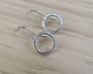 Small sterling silver circles with a hammered finish with handmade ear wires attached.