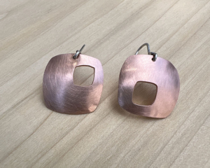 Rounded square copper drops with rounded squares pierced out. Sterling silver Ear wires attached.