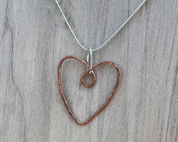 Copper wire made into a heart and hammered and attached to a sterling silver chain.